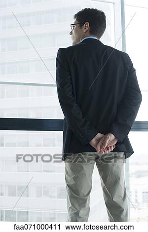 Stock Image - Executive looking out window. Fotosearch