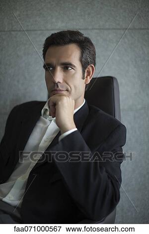 Stock Photo - Executive with hand under chin, portrait. Fotosearch