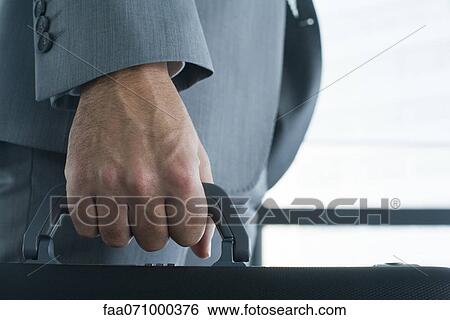 Executive's hand carrying briefcase, mid section, close-up View Large Photo Image Stock Photograph - Executive's hand carrying briefcase, mid section, close-up. Fotosearch