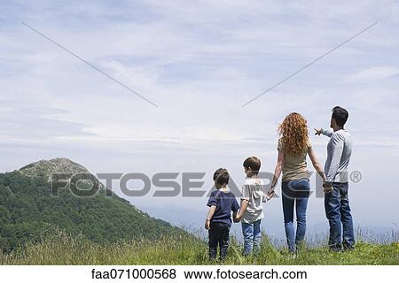 Family enjoying scenic mountain view, rear view View Large Photo Image Stock Photo - Family enjoying scenic mountain view, rear view. Fotosearch