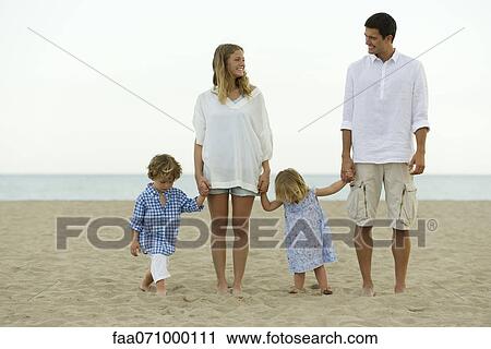 Stock Image - Family holding hands at the beach. Fotosearch