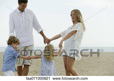 Family holding hands at the beach View Large Photo Image Stock Image - Family holding hands at the beach. Fotosearch