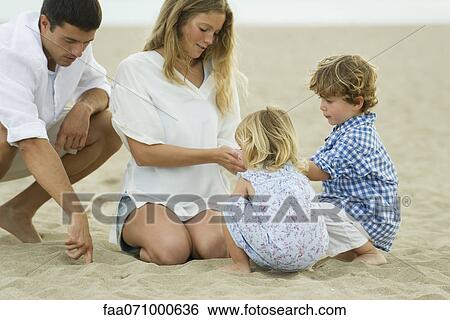 Family playing in sand at the beach View Large Photo Image Stock Photograph - Family playing in sand at the beach. Fotosearch