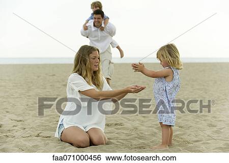 Family playing together at the beach View Large Photo Image Stock Photograph - Family playing together at the beach. Fotosearch