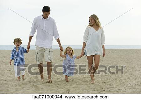 Picture - Family walking hand in hand at the beach. Fotosearch