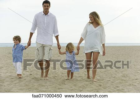 Family walking hand in hand at the beach View Large Photo Image Stock Image - Family walking hand in hand at the beach. Fotosearch