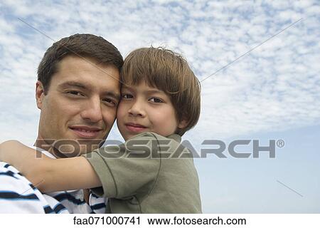 Father and son embracing outdoors, portrait View Large Photo Image Stock Image - Father and son embracing outdoors, portrait. Fotosearch