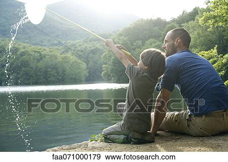 Stock Photo - Father and son fishing, boy holding up fishing net. Fotosearch