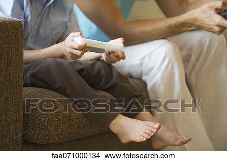 Father and son playing video game together, cropped View Large Photo Image Picture - Father and son playing video game together, cropped. Fotosearch
