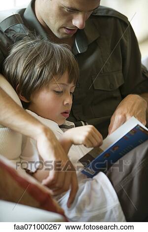 Stock Photo - Father and young son reading together, cropped. Fotosearch