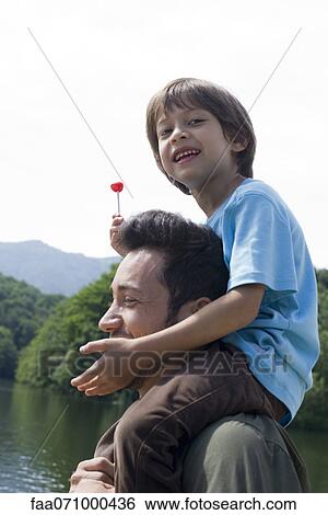 Stock Photograph - Father carrying son on shoulders. Fotosearch