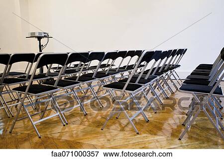Folding chairs lined up in conference room View Large Photo Image Stock Photo - Folding chairs lined up in conference room. Fotosearch