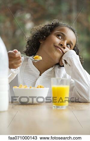 Girl daydreaming at breakfast table View Large Photo Image Stock Image - Girl daydreaming at breakfast table. Fotosearch