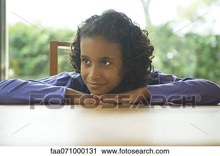 Girl daydreaming at table with head resting on arms View Large Photo Image Stock Image - Girl daydreaming at table with head resting on arms. Fotosearch