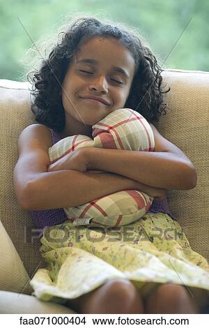 Picture - Girl hugging pillow. Fotosearch