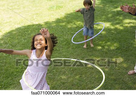 Picture - Girl playing with plastic hoop. Fotosearch