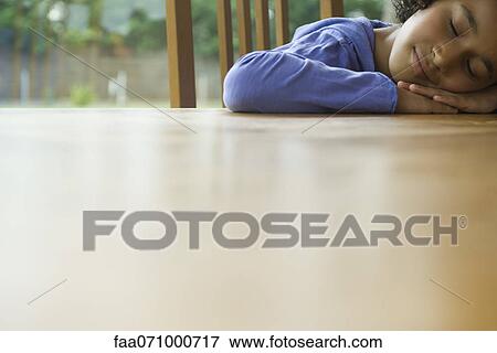 Girl resting head on table View Large Photo Image Stock Photo - Girl resting head on table. Fotosearch