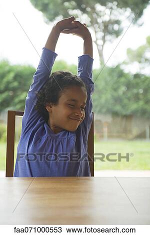 Girl stretching at table View Large Photo Image Stock Image - Girl stretching at table. Fotosearch
