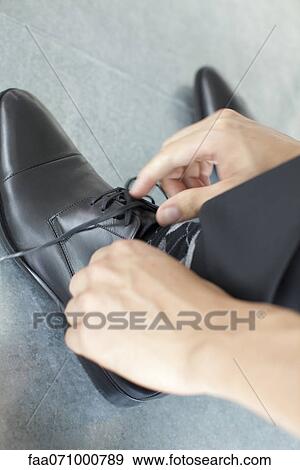 Hands tying shoelace, cropped View Large Photo Image Stock Photo - Hands tying shoelace, cropped. Fotosearch