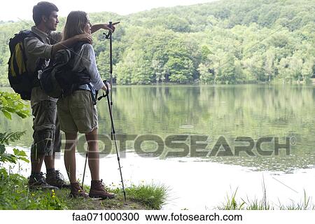 Hiking couple looking at lake View Large Photo Image Stock Image - Hiking couple looking at lake. Fotosearch