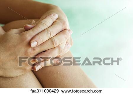 Hugging knees, cropped View Large Photo Image Stock Photo - Hugging knees, cropped. Fotosearch