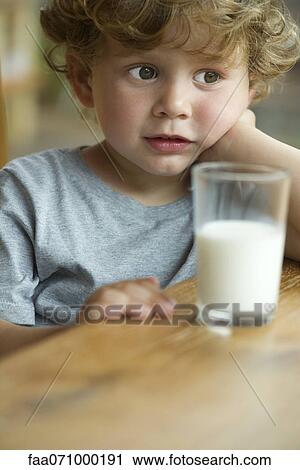 Stock Image - Little boy looking away in thought, portrait. Fotosearch