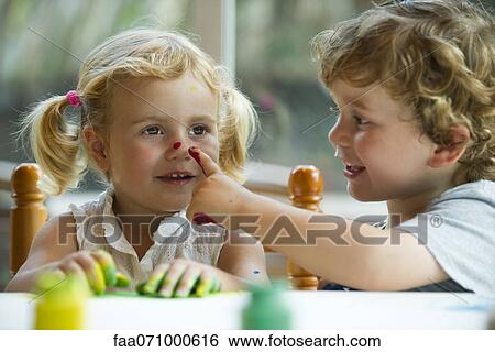 Little boy putting paint on his sister's nose View Large Photo Image Stock Photograph - Little boy putting paint on his sister's nose. Fotosearch