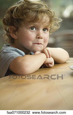 Little boy resting chin on arms, looking away in thought, portrait View Large Photo Image Stock Image - Little boy resting chin on arms, looking away in thought, portrait. Fotosearch