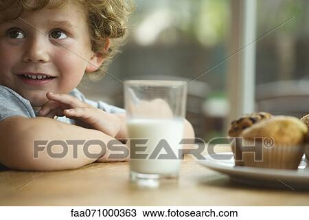 Little boy sitting at table with snack View Large Photo Image Stock Image - Little boy sitting at table with snack. Fotosearch