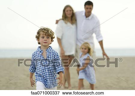 Little boy walking ahead of his family at the beach View Large Photo Image Stock Photo - Little boy walking ahead of his family at the beach. Fotosearch