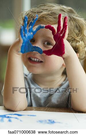 Stock Photo - Little boy with hands covered in paint. Fotosearch