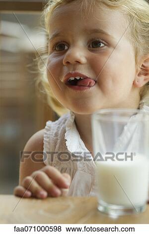 Little girl enjoying glass of milk View Large Photo Image Stock Photo - Little girl enjoying glass of milk. Fotosearch