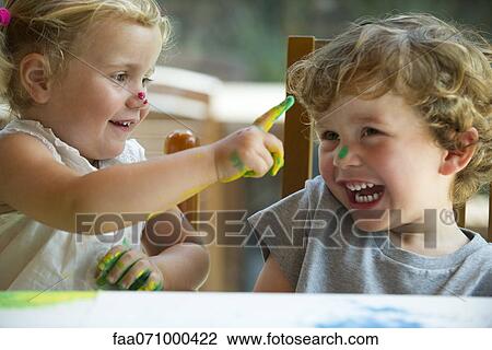 Little girl wiping paint on her brother's nose View Large Photo Image Stock Image - Little girl wiping paint on her brother's nose. Fotosearch