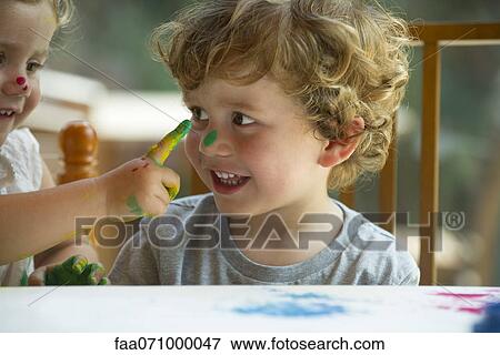 Little girl wiping paint on her brother's face View Large Photo Image Stock Photo - Little girl wiping paint on her brother's face. Fotosearch