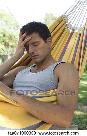 Man in hammock holding head View Large Photo Image Stock Photo - Man in hammock holding head. Fotosearch