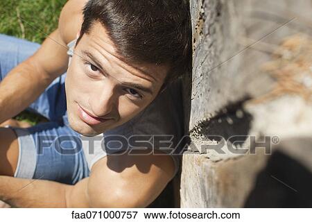 Stock Photo - Man leaning against wall, portrait. Fotosearch