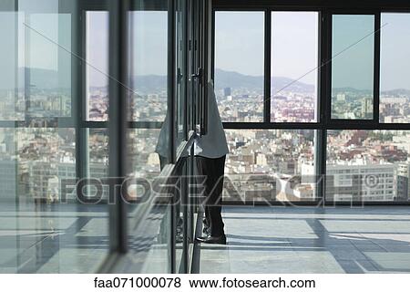 Man leaning out of window looking at city View Large Photo Image Stock Photo - Man leaning out of window looking at city. Fotosearch