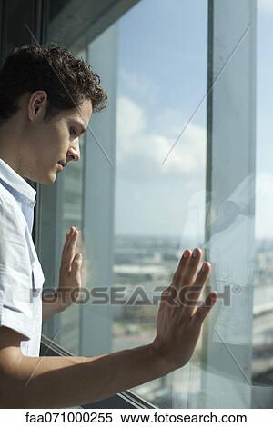 Man looking out of window, side view View Large Photo Image Stock Photography - Man looking out of window, side view. Fotosearch