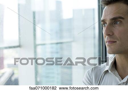 Man looking out of window View Large Photo Image Stock Image - Man looking out of window. Fotosearch