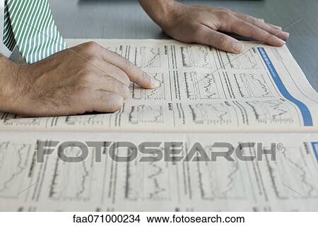Picture - Man reading finance section of newspaper. Fotosearch