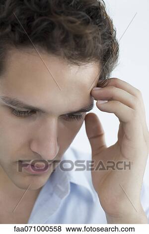Stock Photo - Man with hand on temple. Fotosearch