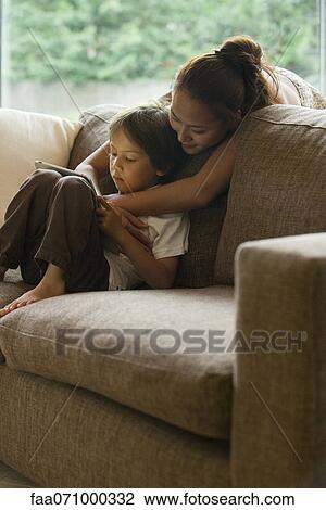 Mother and son looking at digital tablet together View Large Photo Image Stock Image - Mother and son looking at digital tablet together. Fotosearch