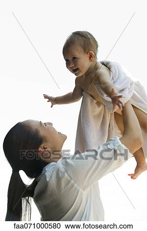 Mother lifting infant in the air View Large Photo Image Stock Image - Mother lifting infant in the air. Fotosearch