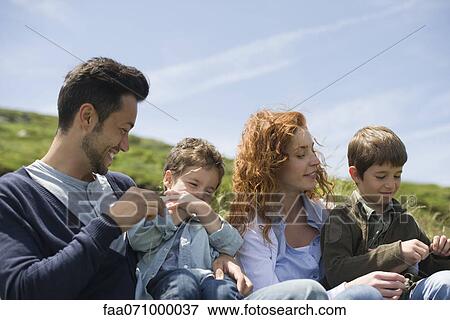 Parents and young boys playing in nature View Large Photo Image Stock Photo - Parents and young boys playing in nature. Fotosearch