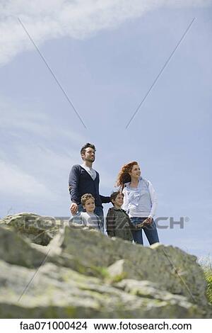 Picture - Parents and young boys standing in nature. Fotosearch