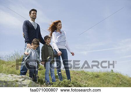 Parents and young boys standing on meadow, portrait View Large Photo Image Stock Photo - Parents and young boys standing on meadow, portrait. Fotosearch
