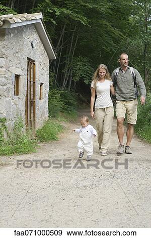 Stock Photo - Parents hiking in woods with toddler. Fotosearch