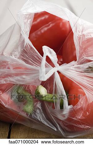 Picture - Red bell peppers in plastic bag. Fotosearch