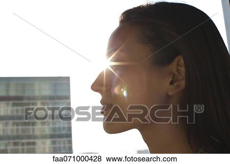 Stock Photo - Silhouette of woman's face, sun shinning in background. Fotosearch