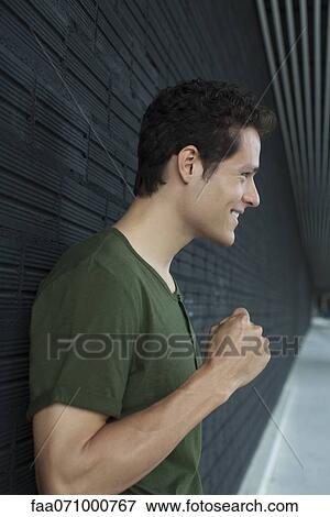 Smiling man holding up fist View Large Photo Image Stock Photo - Smiling man holding up fist. Fotosearch